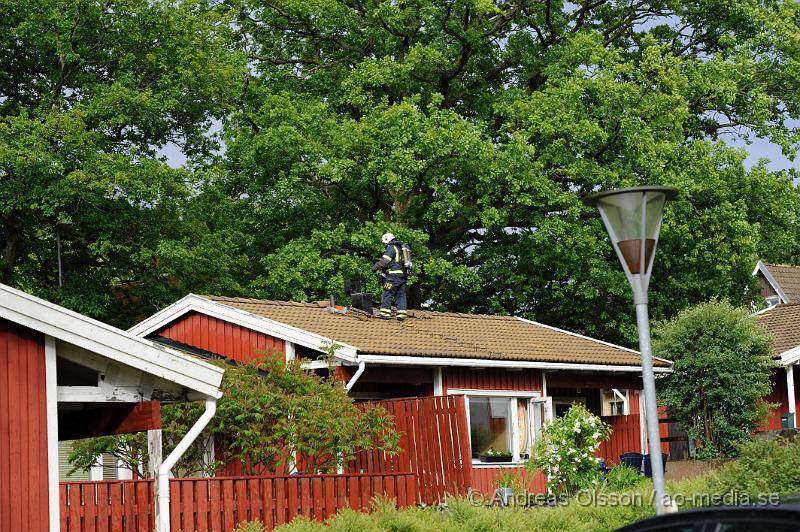 _DSC9130.JPG - Strax efter 18 tiden larmades räddningstjänsten från Perstorp och Hässleholm samt polis och ambulans till snickaregatan i Perstorp där man hade fått in larm om brand i ett av radhusen. På plats konstaterade man brand i köket och branden släcktes snabbt ner. Räddningstjänsten fick bryta upp en del på taket runt skorstenen samt inne i köket för att kontrollera att elden inte spridit sig. Det var en överhettad fritös som orsakade branden. Ingen person kom till skada.