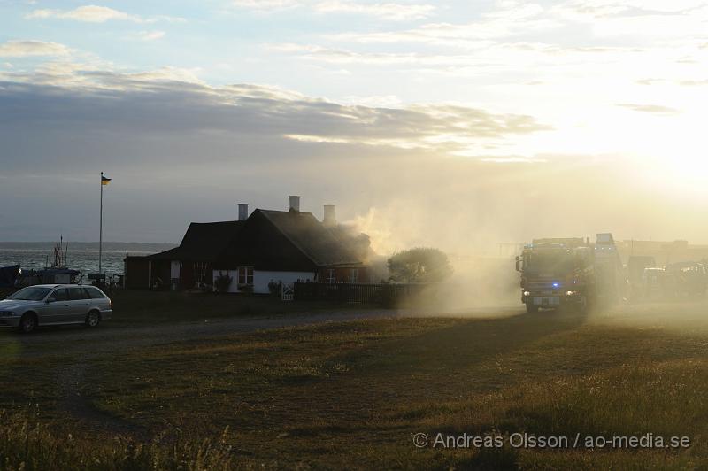 _DSC9426.JPG - Vid 20:20 larmades räddningstjänst, ambulans och polis till Kustgatan i Råå där man hade fått larm om brand i taket på Villa Sjösäker. Väl på plats konstaterade man brand i taket av villan och man skickade in rökdykare och fick såga upp hål i taket för att komma åt branden. Man lyckades rädda villan från totalskada men stora delar av huset blev rökskadat, störst skada blev det i den norra delen av huset. Huset är från 1800 talet och har renoverats i omgångar. Man misstänker att branden startat efter takarbete. Även en person ska ha skadat handen i branden.