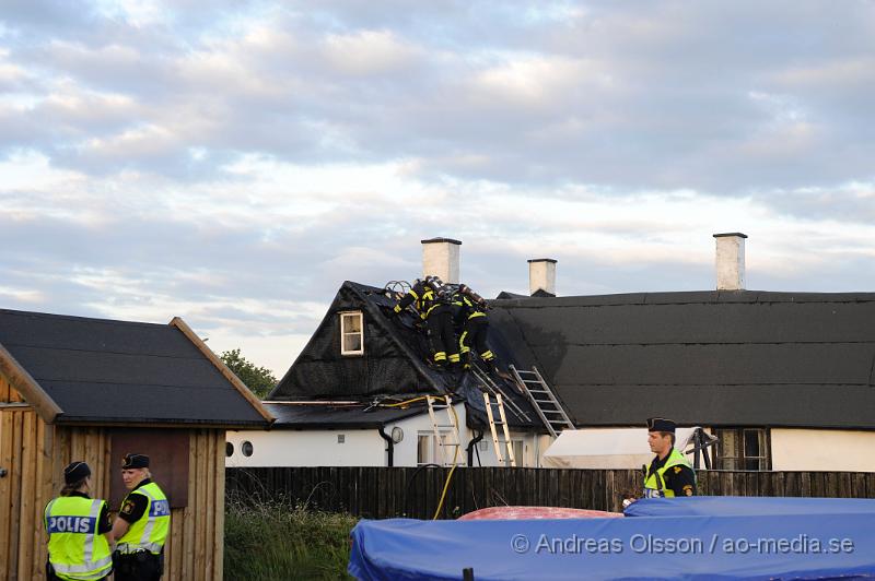 _DSC9442.JPG - Vid 20:20 larmades räddningstjänst, ambulans och polis till Kustgatan i Råå där man hade fått larm om brand i taket på Villa Sjösäker. Väl på plats konstaterade man brand i taket av villan och man skickade in rökdykare och fick såga upp hål i taket för att komma åt branden. Man lyckades rädda villan från totalskada men stora delar av huset blev rökskadat, störst skada blev det i den norra delen av huset. Huset är från 1800 talet och har renoverats i omgångar. Man misstänker att branden startat efter takarbete. Även en person ska ha skadat handen i branden.