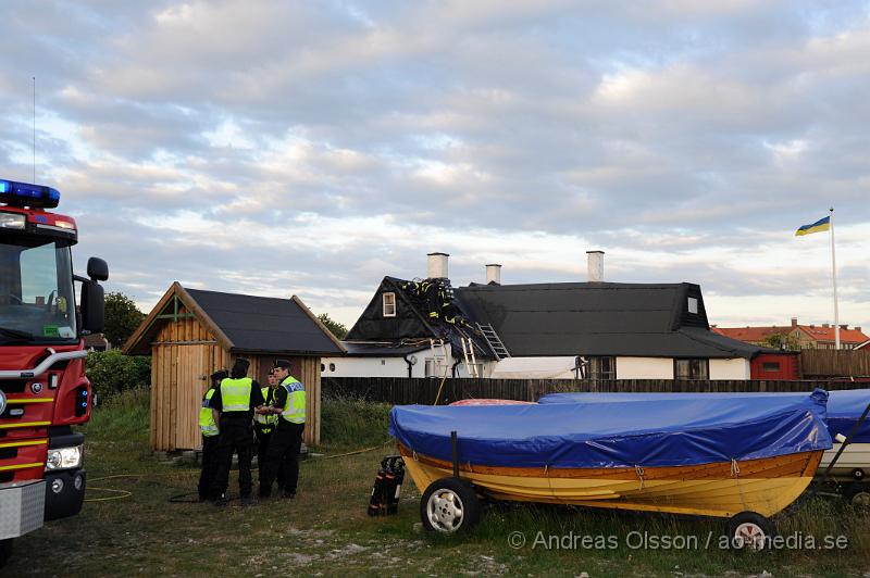 _DSC9447.JPG - Vid 20:20 larmades räddningstjänst, ambulans och polis till Kustgatan i Råå där man hade fått larm om brand i taket på Villa Sjösäker. Väl på plats konstaterade man brand i taket av villan och man skickade in rökdykare och fick såga upp hål i taket för att komma åt branden. Man lyckades rädda villan från totalskada men stora delar av huset blev rökskadat, störst skada blev det i den norra delen av huset. Huset är från 1800 talet och har renoverats i omgångar. Man misstänker att branden startat efter takarbete. Även en person ska ha skadat handen i branden.