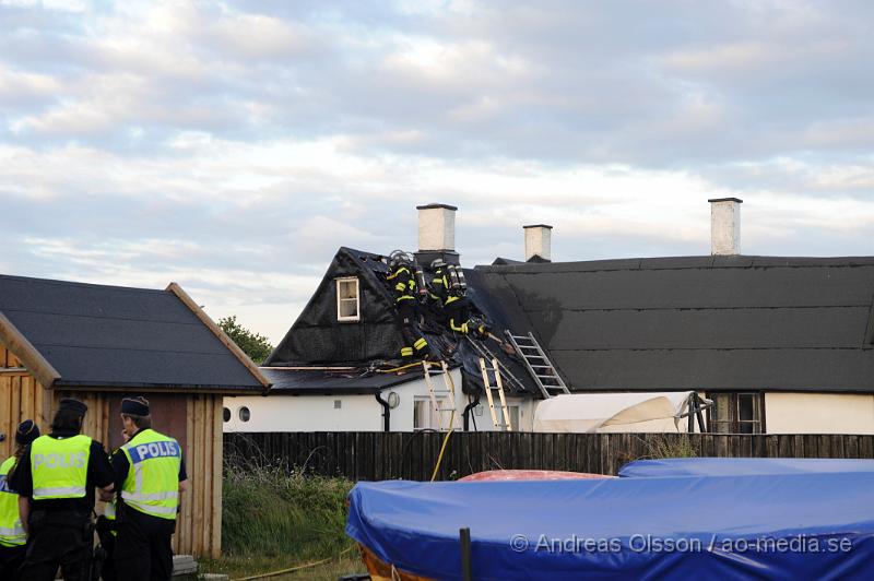 _DSC9450.JPG - Vid 20:20 larmades räddningstjänst, ambulans och polis till Kustgatan i Råå där man hade fått larm om brand i taket på Villa Sjösäker. Väl på plats konstaterade man brand i taket av villan och man skickade in rökdykare och fick såga upp hål i taket för att komma åt branden. Man lyckades rädda villan från totalskada men stora delar av huset blev rökskadat, störst skada blev det i den norra delen av huset. Huset är från 1800 talet och har renoverats i omgångar. Man misstänker att branden startat efter takarbete. Även en person ska ha skadat handen i branden.