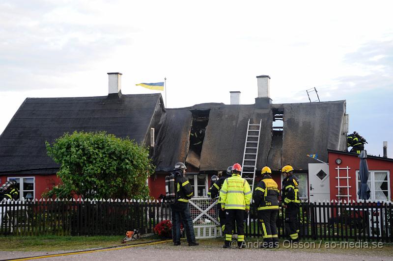 _DSC9454.JPG - Vid 20:20 larmades räddningstjänst, ambulans och polis till Kustgatan i Råå där man hade fått larm om brand i taket på Villa Sjösäker. Väl på plats konstaterade man brand i taket av villan och man skickade in rökdykare och fick såga upp hål i taket för att komma åt branden. Man lyckades rädda villan från totalskada men stora delar av huset blev rökskadat, störst skada blev det i den norra delen av huset. Huset är från 1800 talet och har renoverats i omgångar. Man misstänker att branden startat efter takarbete. Även en person ska ha skadat handen i branden.