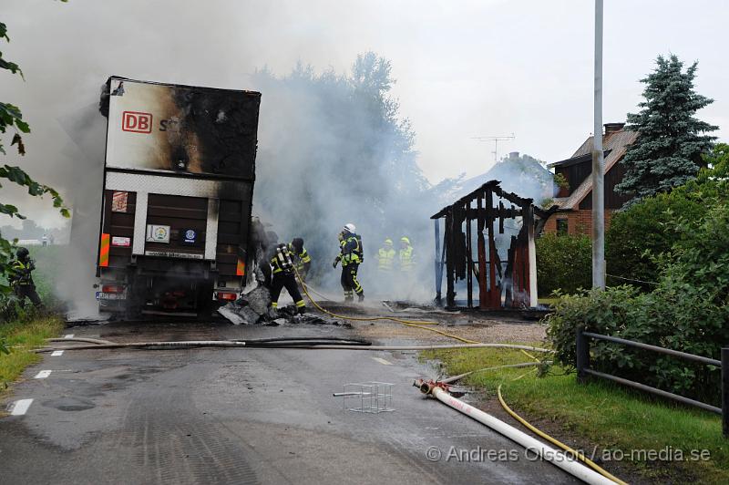 _DSC9678.JPG - Vid 11.10 larmades räddningstjänsten från Klippan och Ljungbyhed samt polis och ambulans till Stackarp strax utanför Klippan där en lastbil kolliderat med en personbil . Lastbilen började strax efter kollisionen brinna och branden spred sig till en mindre byggnad intill samt lite gräs. När räddningstjänsten kom till platsen var lastbilen helt övertänd och totalförstördes precis som byggnaden. En person i personbilen fick följa med ambulansen med oklara skador. Lastbils föraren chockades. Lastbilen ska ha varit lastad med trävaror. Vägen var helt avstängd under räddnings och bärgnings arbetet.