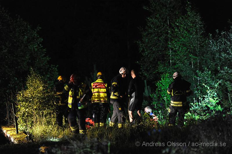 _DSC0154.JPG - Vid 23:20 larmades räddningstjänsten från Perstorp, Hässleholm, Höganäs samt ambulans och polis till Ebbarps kraftverksdammar. Det var en personbil som av oklar anledning kört över kanten till en ravin på ca 6 meter och ner i bäljane å. Bilen stod fastkilad rakt upp och en person befann sig i bilen. Det var när mannen varit ute på några korta ärenden och sedan inte kommit hem som anhöriga började bli oroliga och ringde polisen. Dem hämtade då upp frun och körde den vägen som mannen skulle ha kört och fann då bilen. Då ska mannen ha suttit fast i bilen i ca 30-60 minuter. Räddningsarbetet blev komplicerat då man inte hade något säkert sätt att få ut mannen på först. Man säkrade bilen och började sedan tänka ut en bra lösning för att få ut mannen säkert. Det slutade med att man lyckades stå i ån som inte var så djup och fick ut mannen på en såkallad spineboard och kunde då bära iväg honom genom ån till en bättre plats för att sedan få upp honom till ambulansen. Mannen ska ha varit vaken och pratat med räddningspersonalen under hela räddningsarbetet. Han fördes med ambulans till sjukhus för kontroll av en del sårskador men ska mirakulöst ha klarat sig relativt bra.