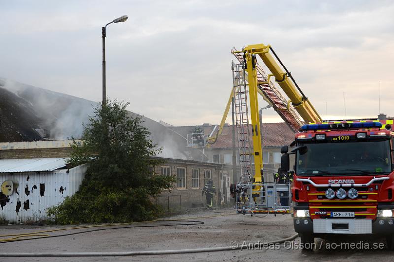 DSC_0477.JPG - Vid 19 tiden larmades en större räddningsstyrka till Skogsgatan i Helsingborg där det kom svart rök från swebus gamla bussgarage. När räddningstjänsten kom till platsen brann det med öppna lågor från taket. Byggnaden är kulturskyddad och det är oklart om räddningstjänsten lyckas rädda byggnaden för det brinner under taket som är gjort av eternitplattor. Strax innan det började brinna i byggnade har vittnen berättat att man sett minst fyra personer lämna området.  Ingen person ska ha kommit till skada.