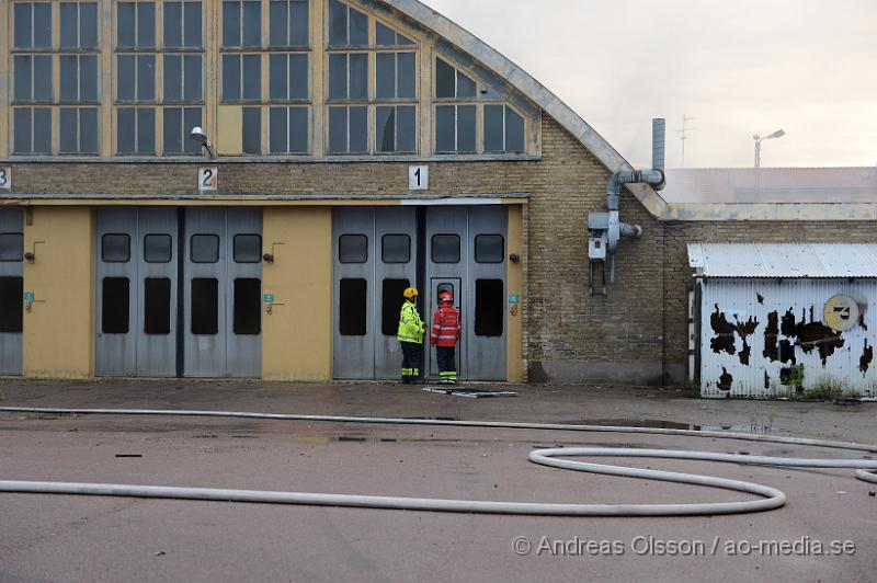 DSC_0478.JPG - Vid 19 tiden larmades en större räddningsstyrka till Skogsgatan i Helsingborg där det kom svart rök från swebus gamla bussgarage. När räddningstjänsten kom till platsen brann det med öppna lågor från taket. Byggnaden är kulturskyddad och det är oklart om räddningstjänsten lyckas rädda byggnaden för det brinner under taket som är gjort av eternitplattor. Strax innan det började brinna i byggnade har vittnen berättat att man sett minst fyra personer lämna området.  Ingen person ska ha kommit till skada.