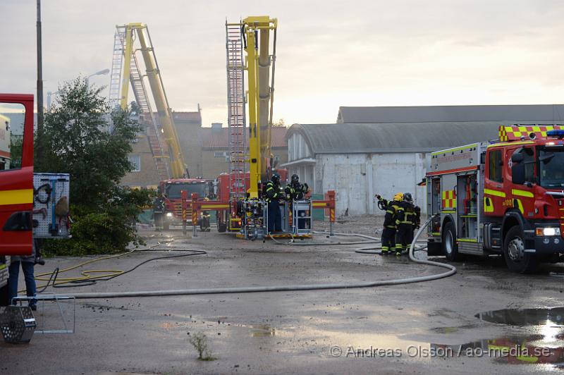 DSC_0481.JPG - Vid 19 tiden larmades en större räddningsstyrka till Skogsgatan i Helsingborg där det kom svart rök från swebus gamla bussgarage. När räddningstjänsten kom till platsen brann det med öppna lågor från taket. Byggnaden är kulturskyddad och det är oklart om räddningstjänsten lyckas rädda byggnaden för det brinner under taket som är gjort av eternitplattor. Strax innan det började brinna i byggnade har vittnen berättat att man sett minst fyra personer lämna området.  Ingen person ska ha kommit till skada.