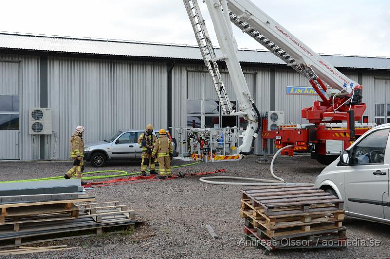 DSC_1164.JPG - Vid 16.10 larmades en större räddningsstyrka till Produktionsvägen i Ängelholm där man fått in larm om brand i taket på en industribyggnad. När räddningstjänsten kom till plats hade man brand i innertaket på byggnaden och man började släckningsarbetet invändigt. Man skickade även upp två brandmän till taket och sågade upp en bit för att vara säkra på att det inte hade fått mer fäste under. Branden var släckt på ungefär 30 minuter. Ingen person kom till skada.