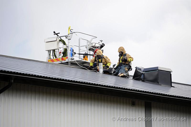 _DSC2453.JPG - Vid 16.10 larmades en större räddningsstyrka till Produktionsvägen i Ängelholm där man fått in larm om brand i taket på en industribyggnad. När räddningstjänsten kom till plats hade man brand i innertaket på byggnaden och man började släckningsarbetet invändigt. Man skickade även upp två brandmän till taket och sågade upp en bit för att vara säkra på att det inte hade fått mer fäste under. Branden var släckt på ungefär 30 minuter. Ingen person kom till skada.