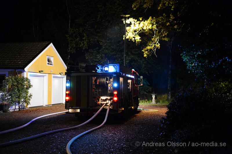 DSC_1469.JPG - Strax innan 00:00 på måndagskvällen larmades räddningstjänsten, ambulans och polis till Killhult i Skånes Fagerhult där det inkommit ett larm om att en fristående byggnad brann, vid framkomst va det fullt utvecklad brand. I byggnaden fanns bla ett släp och en hel del ved, ca  5-6 kubikmeter. Det gjorde att branden blev väldigt svår att släcka helt då vattnet inte kom åt överallt och man fick ta in en hjullastare som kunde få ut veden så man kunde släcka ner det ordentligt. Det är oklart hur branden starta men man misstänker att den är anlagd.