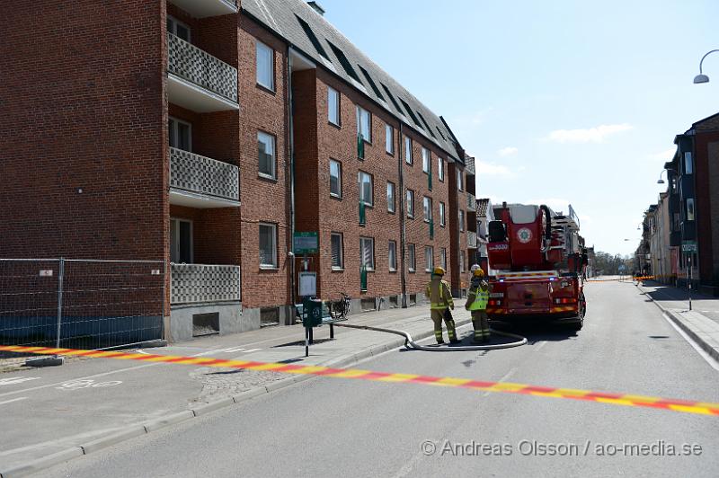 DSC_5370.JPG - På eftermiddagen larmades en större styrka till en misstänkt lägenhetsbrand i centrala Ängelholm, enligt inringare var det kraftig svart rökutveckling från en vindsvåning. Det är oklart vad som brunnit men branden kunde snabbt släckas ner av räddningstjänsten. Ingen person ska ha kommit till skada. Vägen utanför spärrades av under släcknings arbetet.