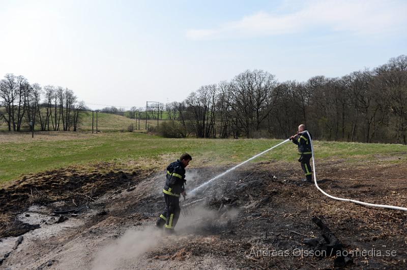 DSC_5529.JPG - Vid 13,50 larmas räddningstjänsten till Bjärsgård strax utanför Klippan där det ska brinna i majbålet igen. När räddningstjänsten kommer fram till platsen ryker det lite ur resterna och man blöter ner området med vatten.