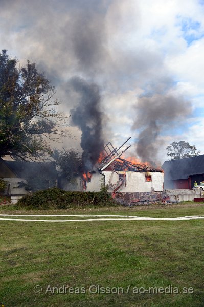 DSC_6038.JPG - Vid 14.40 larmades en större räddningsstyrka till Forsby strax utanför Klippan där man fått in larm om brand i en ladugård. Påväg till platsen såg man kraftig rökutveckling och framme på plats kunde man konstatera att det var en fullt utvecklad brand i ladugården som låg precis intill boningshuset. I ladugården fanns det hönor,Kycklingar och kaniner. Man hann få ut och rädda en del hönor men flera kycklingar samt en eller flera kaniner klarade sig inte undan lågorna. Branden hade fått sånt fäste i byggnaden att räddningstjänsten inriktade sig på att förhindra branden att sprida sig till närliggande byggnader och detta lyckades man med, dock brann hela ladugården ner. Inga personer ska ha skadats i olyckan.